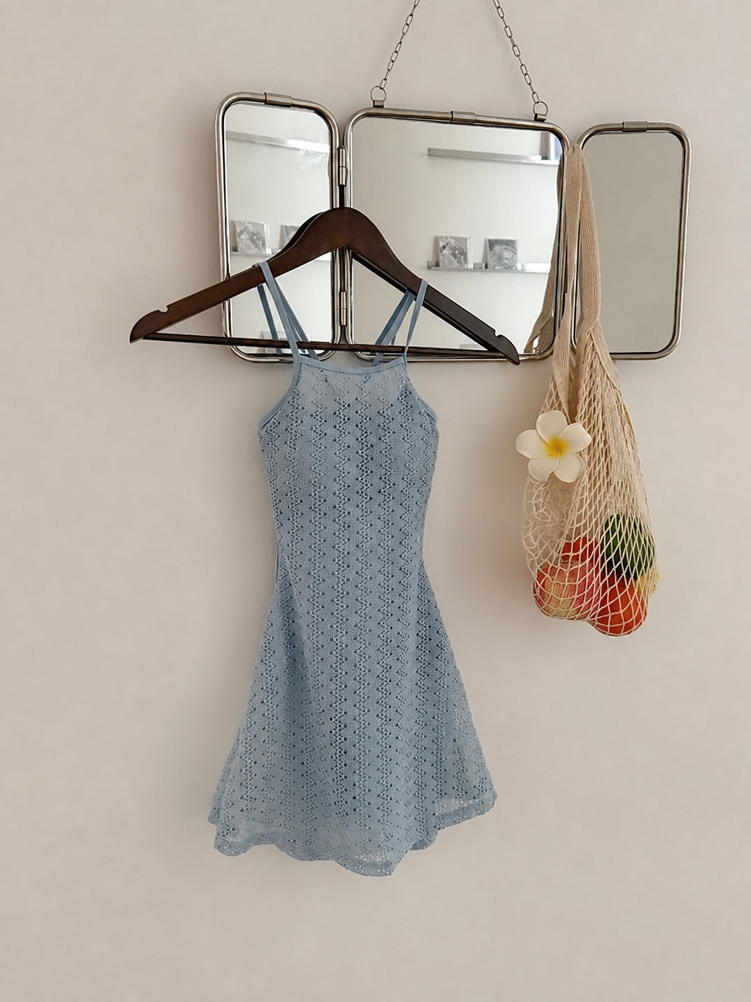 Coast Tempo Mist Blue Cutout Swim Dress hanging against a cream wall